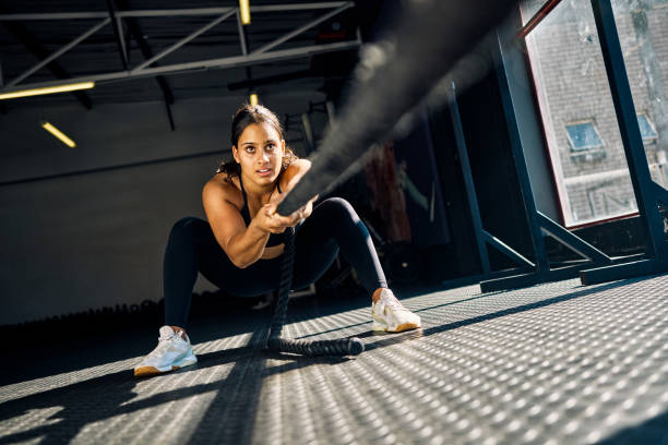female athlete pulling a weighted sled in a gym
